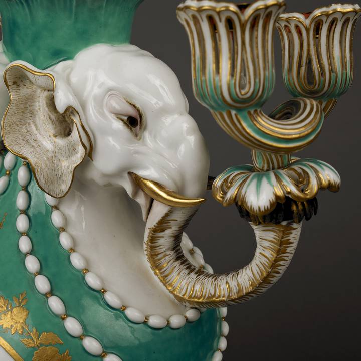 Side view detail of green and white vase with elephant head