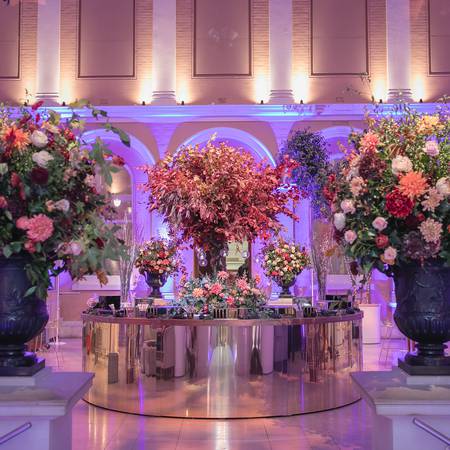 Courtyard with a central drinks bar flanked by floral displays