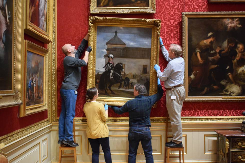 Figures removing a painting from gallery wall