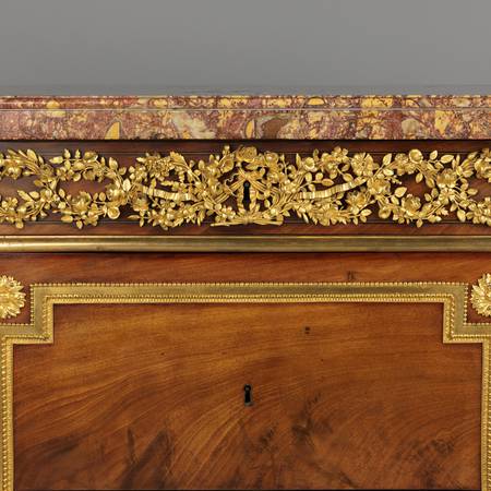 A detail of gilt-bronze mounts on a chest-of-drawers