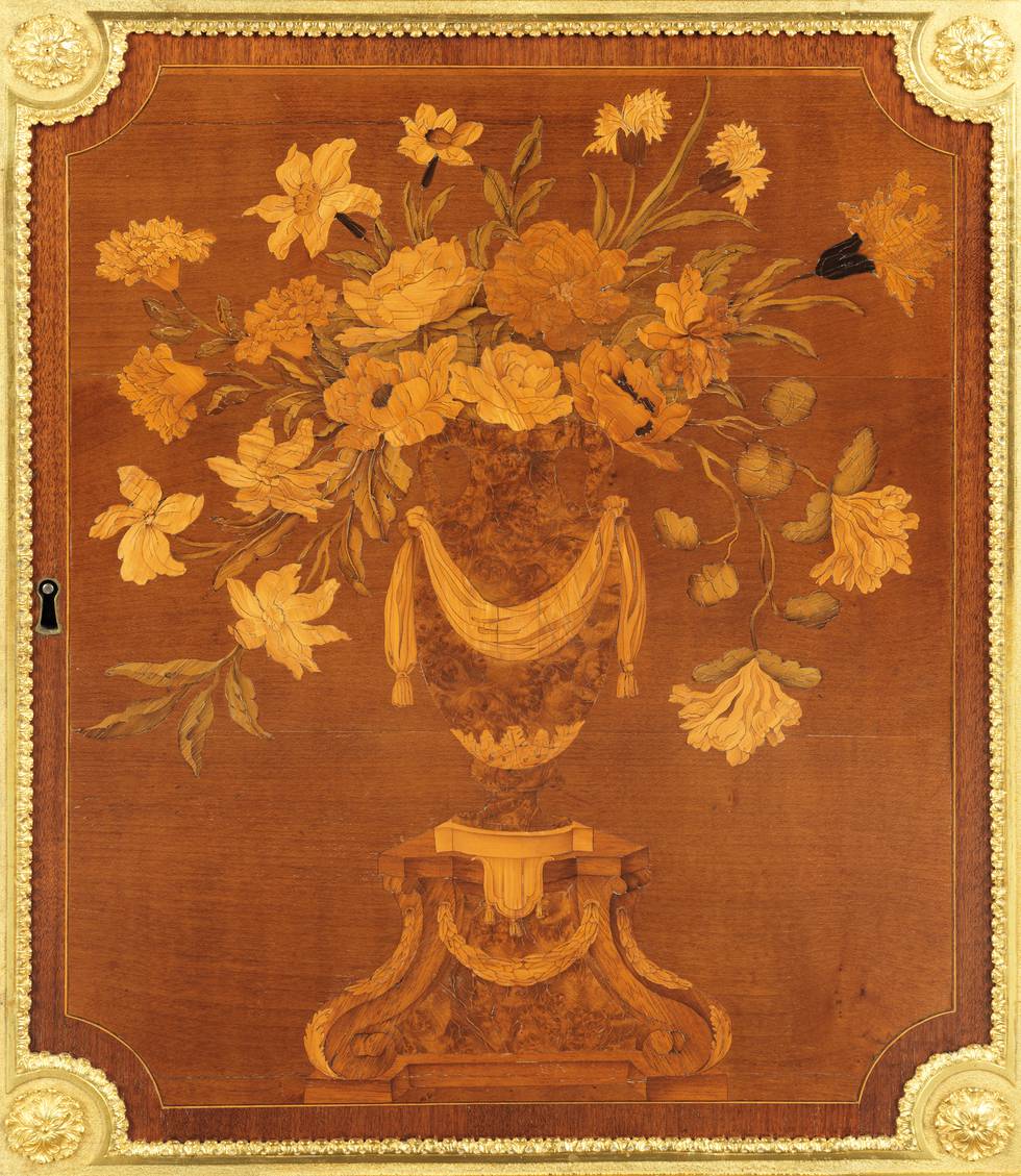 A detail of the marquetry floral vase on one of the lower doors of a fall-front desk
