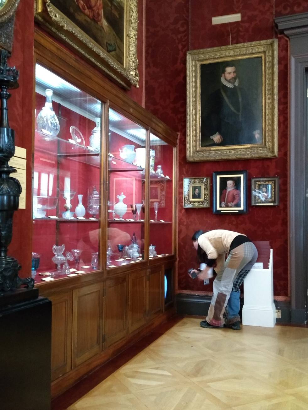 Women crouching by cabinet a gallery at The Wallace Collection