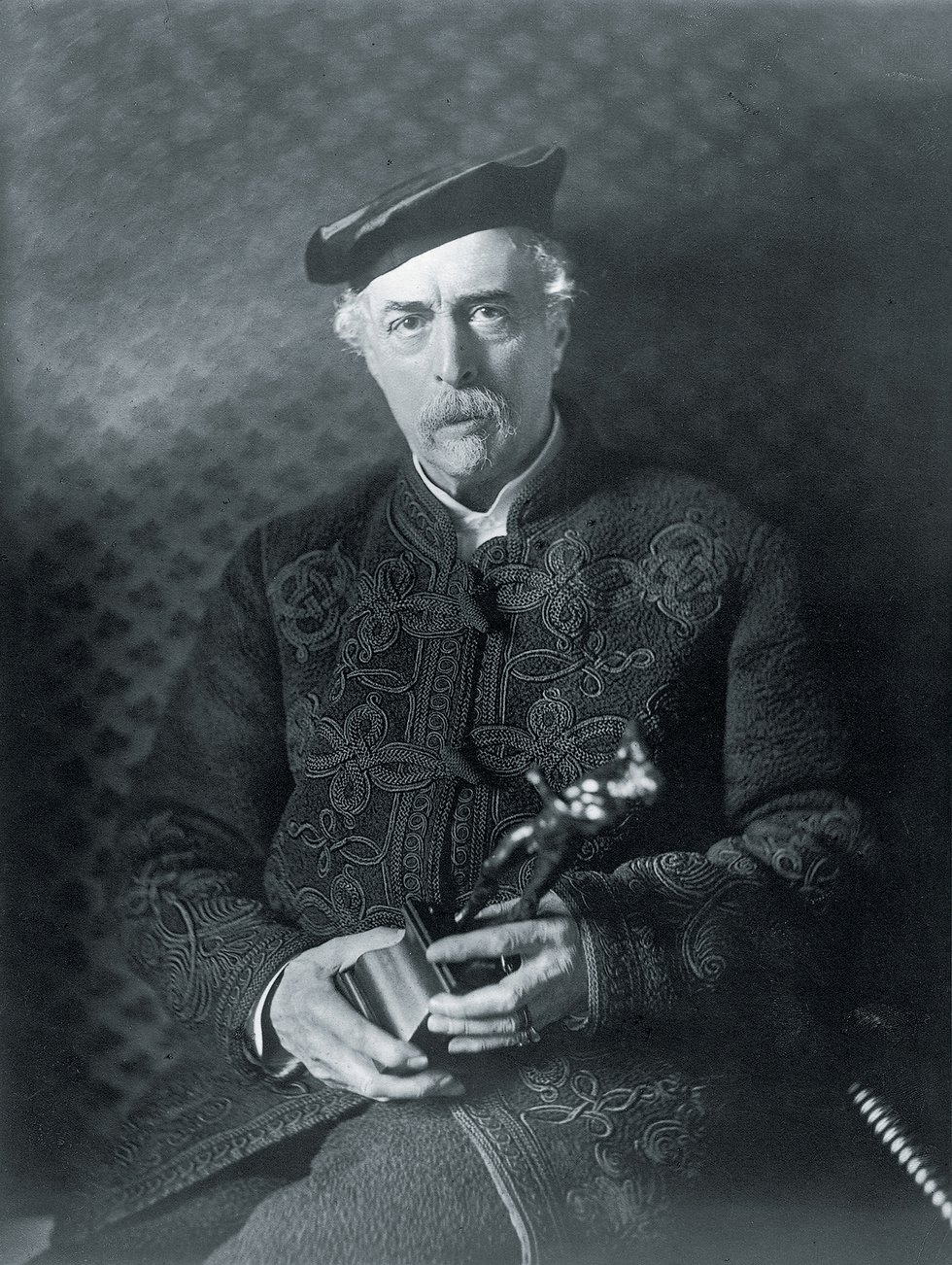 Black and white photo of Richard Wallace holding sculpture