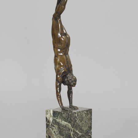 Bronze sculpture of naked man doing a handstand