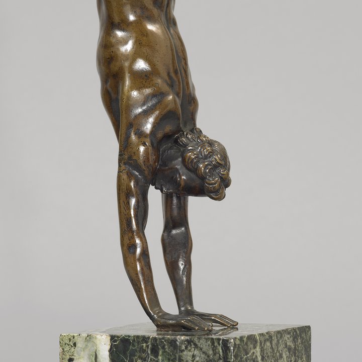 Detail of bronze sculpture of man doing handstand