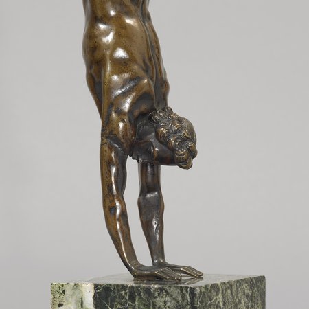 Detail of bronze sculpture of man doing handstand