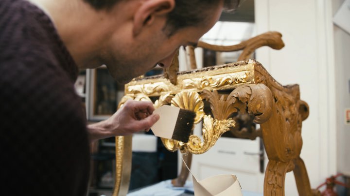 Man brushing gold leaf on chair