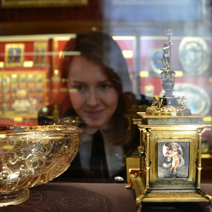 Curator inspecting objects in a glass cabinet