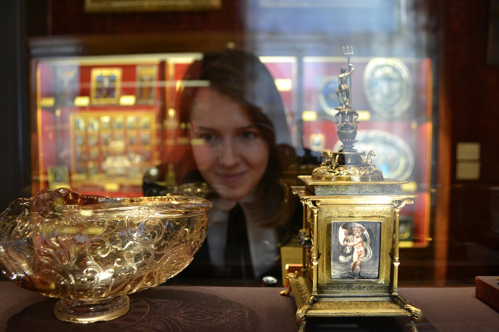 Curator inspecting objects in a glass cabinet