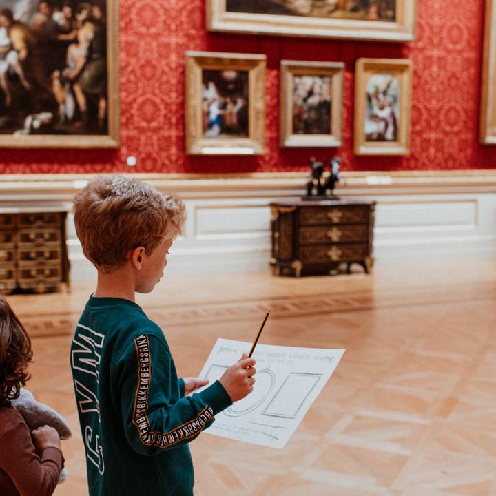 View through a door frame of paintings on gallery wall